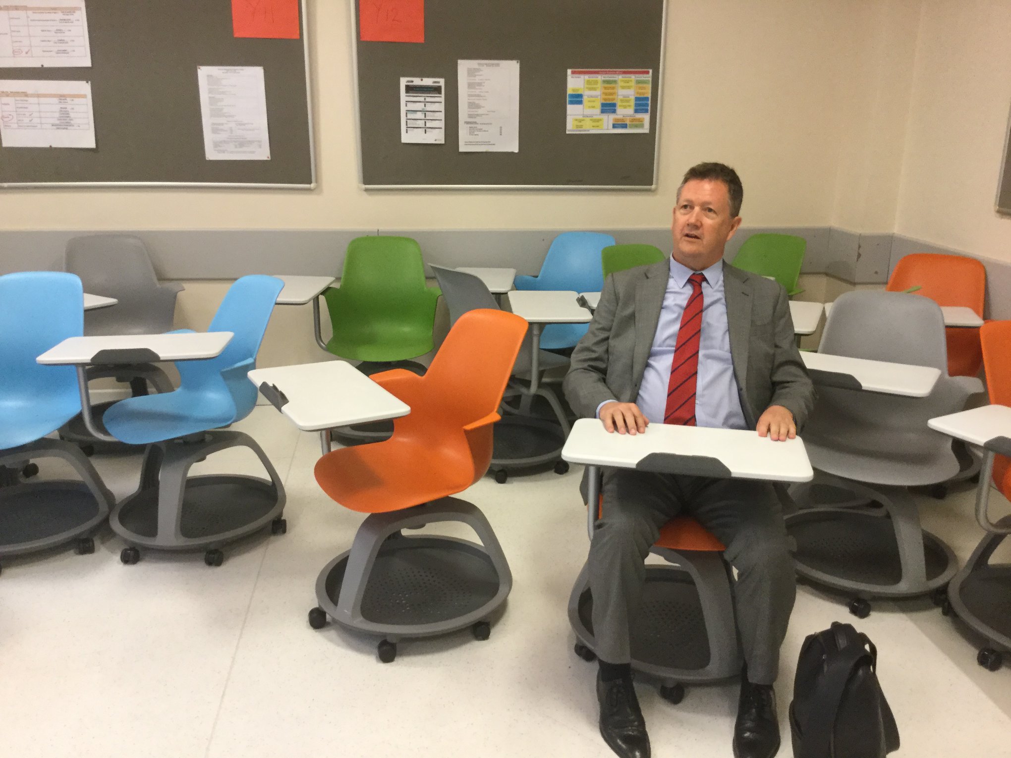 Bill tries out a colorful student desk at The KOC School, Istanbul