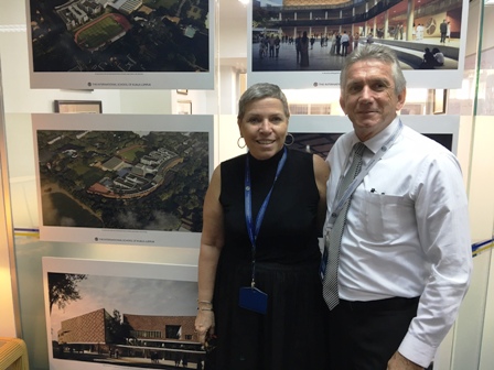 Head of School Norma Hudson and Senior Associate Ray Sparks stand in front of photos of the new campus